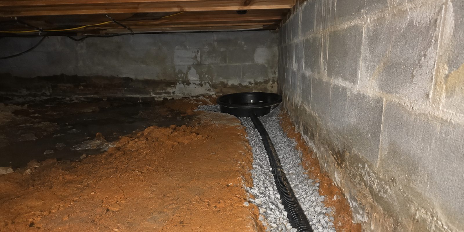 Perimeter drain and sump basin installed in a crawl space in Huntsville, Alabama
